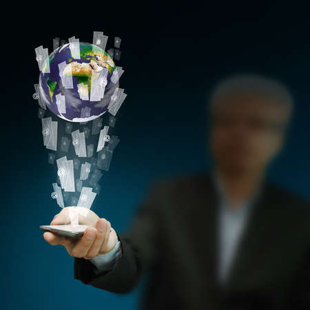 Young stylish businessman touching virtual interface button. Pillar of transparent blue light. Future bio style interior on background. Interfaces collection.の写真素材