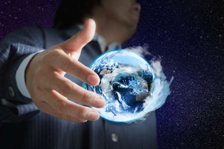 holding a glowing earth globe in his handsの写真素材