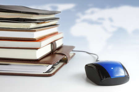 Stack of books and mouse. Online education and business concept.の写真素材