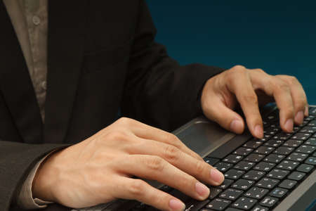 Young stylish businessman touching virtual interface button. Pillar of transparent blue light....