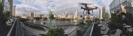Drone quad copter with high resolution digital camera on the sky mountain and city background.