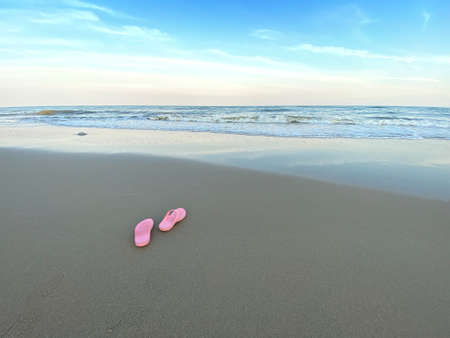 Summer holiday concept. Pair of pink sandals on the beach.の写真素材