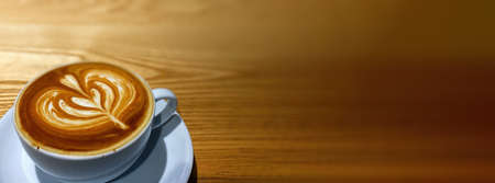 Hot art Latte Coffee in a cup on wooden table.の写真素材