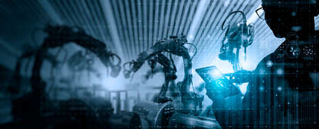 Factory Female Industrial Engineer working with automation robot arms machine in intelligent factory...