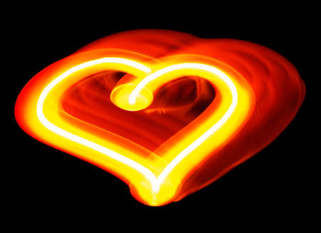 Light painting of heart made by moving hand-held candle isolated on black backgroundの写真素材