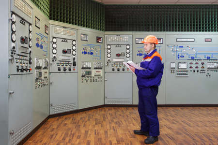 Engineer writes in log on main control panel of gas compressor stationの写真素材