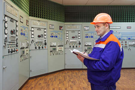 Engineer with log on main control panel of compressor station, focus on manの写真素材