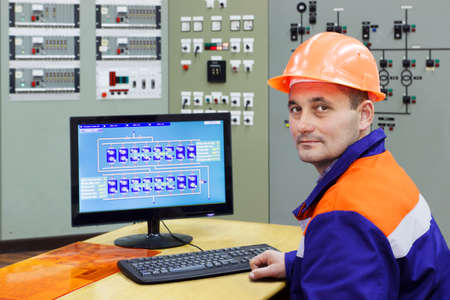 Engineer at the computer on main control panel of gas compressor station, focus on faceの写真素材