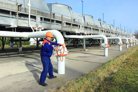 Worker opening valve on gas compressor stationの写真素材