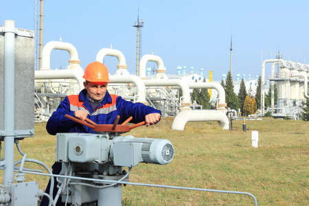 Worker turns bypass valve on gas compressor stationの写真素材