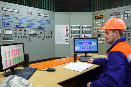 Engineer at the workplace on main control panel of gas compressor station, close-upの写真素材