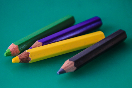 Four colored pencils (green, purple, yellow, black)の写真素材