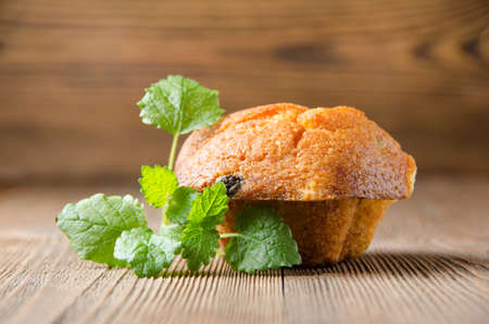 cake with raisins on a brown wooden background with mintの写真素材