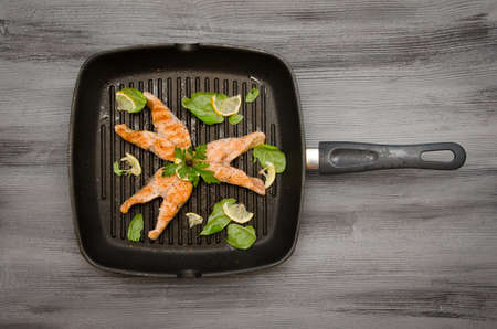 group of pink salmon steaks grill on gray wooden backgroundの写真素材