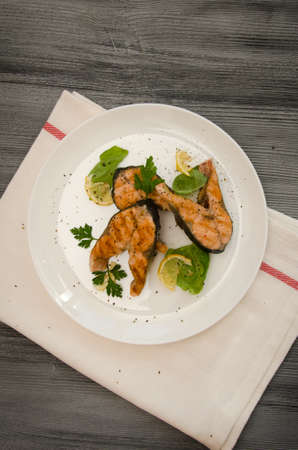 several salmon steaks plate spices on gray wooden tableの写真素材