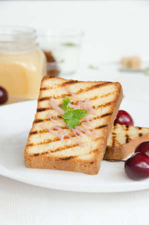 two toasts white bread white round plate with cream and mint leavesの写真素材