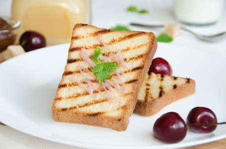 toasts white bread white round plate with cream and mint leavesの写真素材