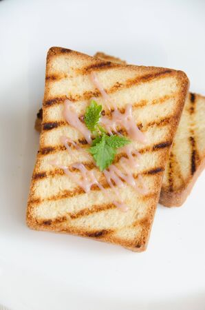 two toasts white round plate with cream and mint leavesの写真素材