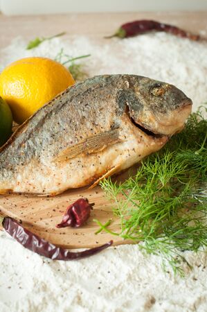roasted dorado table on a round cutting boardの写真素材