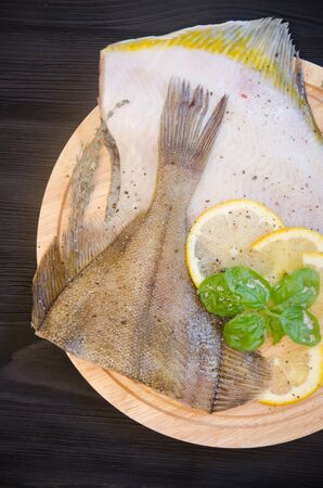 raw fish sole lemon basil on a black wooden background Flat lay close upの写真素材