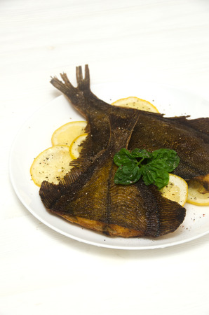 roasted sole round white plate lemon basil on a white backgroundの写真素材