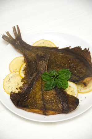 prepared sole round white plate lemon basil on a white backgroundの写真素材