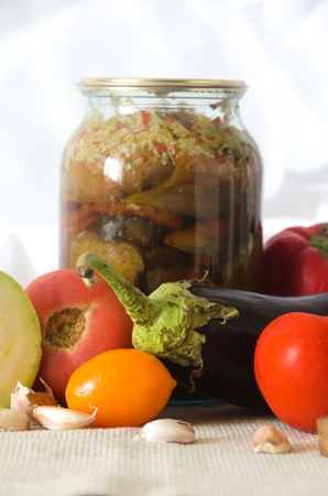 canned vegetables cutting board eggplant tomato garlic on light backgroundの写真素材