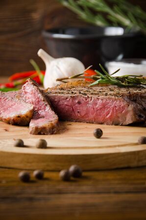 rare steak wooden cutting board on a brown wooden backgroundの写真素材
