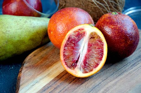 four blood oranges fruits on a dark textured backgroundの写真素材
