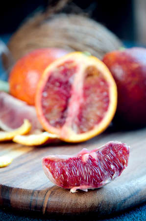 group of blood oranges cutting board on a dark textured backgroundの写真素材