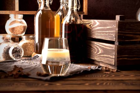 Tincture alcohol  propolis  herbs  glass water on a rustic wooden background with bottles and wooden boxの写真素材