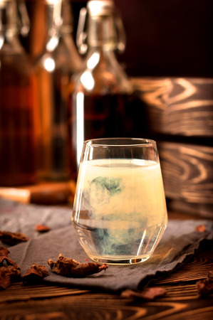alcohol  drinks propolis  herbs  glass water on a rustic wooden background with bottles and wooden boxの写真素材