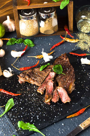 bbq steak beef black square plate pepper on dark backgroundの写真素材