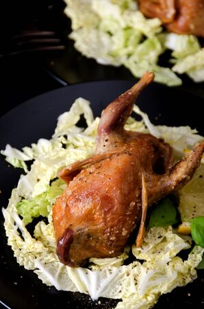 quail game baked lemon salt spices on a black plate close upの写真素材