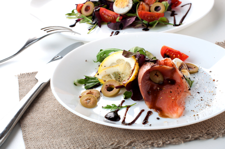 salmon salad white plate olives lemon sauce on a white backgroundの写真素材