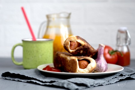 baked sausages dough sea buckthorn tomato on a rustic backgroundの写真素材