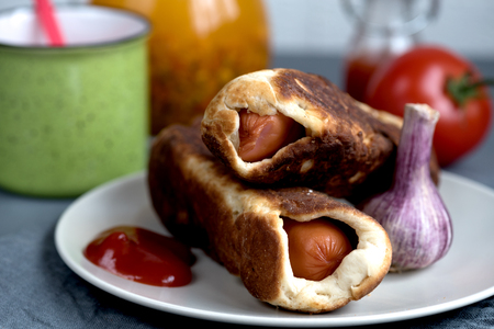 baked sausages dough sea buckthorn tomato juice on a rustic backgroundの写真素材