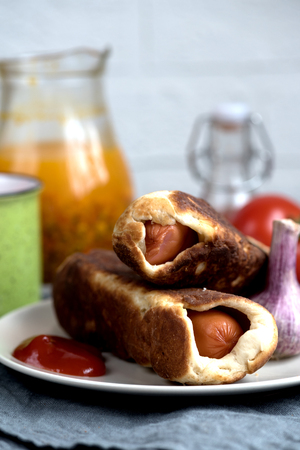 baked sausages dough sea buckthorn garlic juice on a rustic backgroundの写真素材