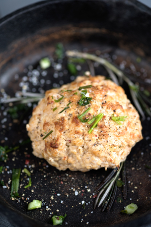 Cooked baked cutlet pan greenery garlic spices on a gray background close-upの写真素材