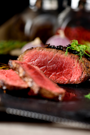 roasted rare steak black angus close up on black rectangular plate with pea sprout thyme rosemary spiceの写真素材