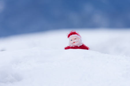 Santa Claus toy climbing on snowy hillの写真素材