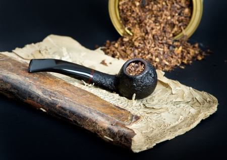 Smoking pipe with smoking tobacco on very old book の写真素材