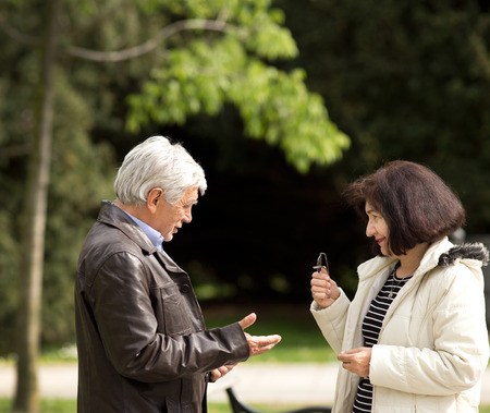 Senior man and woman flirting in parkの写真素材