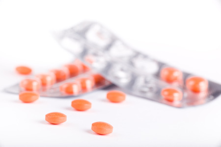 Orange pills and blisters isolated on white background