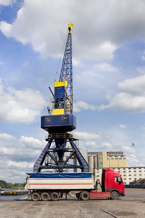 Loading truck by crane in river harbor