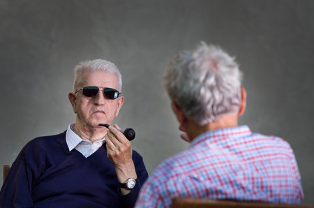 Two old man with sunglasses discussing about secret subjectsの写真素材