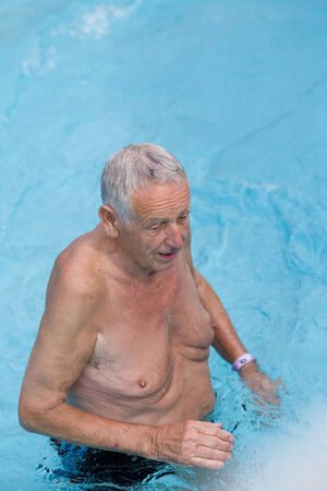 Happy senior man enjoying in swimming poolの写真素材