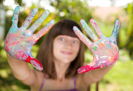 Young student girl showing colorful painted handsの写真素材