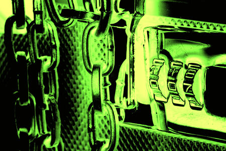Green image of metallic suitcase with safety code and chains around itの写真素材