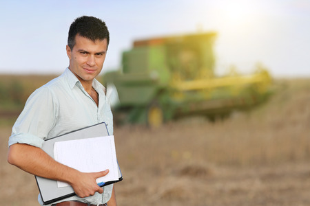 Young satisfied landowner supervising soybean harvesting work